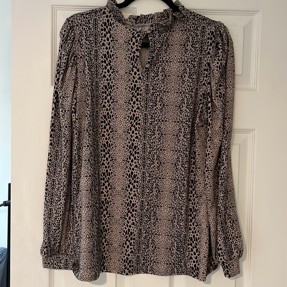 Large animal print blouse with ruffled collar and poofy sleeves.
